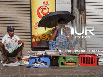 A street vendor takes a call from his mobile phone during the curfew period in Colombo, Sri Lanka, on September 22, 2024. Curfew is imposed...