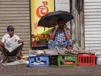 A street vendor takes a call from his mobile phone during the curfew period in Colombo, Sri Lanka, on September 22, 2024. Curfew is imposed...