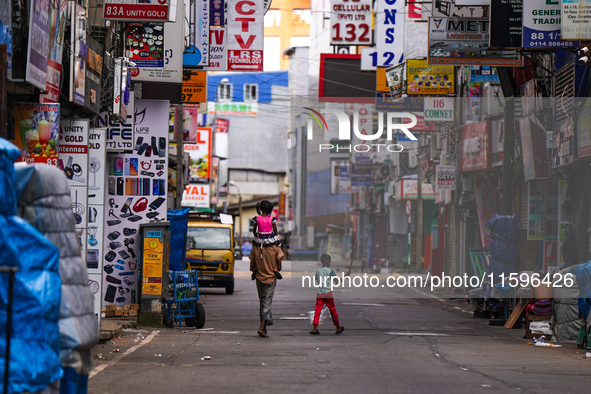 A family walks on the empty street in Colombo, Sri Lanka, on September 22, 2024. A curfew is imposed in Sri Lanka amid the counting of votes...