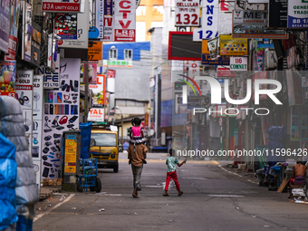 A family walks on the empty street in Colombo, Sri Lanka, on September 22, 2024. A curfew is imposed in Sri Lanka amid the counting of votes...