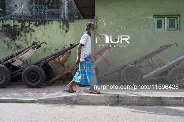 A man walks in front of the carts during the curfew time in Colombo, Sri Lanka, on September 22, 2024. Curfew is imposed in Sri Lanka amid t...