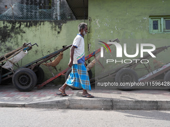 A man walks in front of the carts during the curfew time in Colombo, Sri Lanka, on September 22, 2024. Curfew is imposed in Sri Lanka amid t...