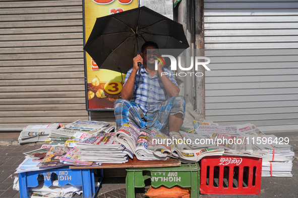 A street vendor takes a call from his mobile phone during the curfew period in Colombo, Sri Lanka, on September 22, 2024. Curfew is imposed...