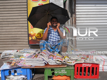 A street vendor takes a call from his mobile phone during the curfew period in Colombo, Sri Lanka, on September 22, 2024. Curfew is imposed...