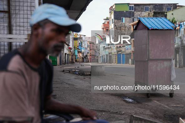 A man sits on the empty street in Colombo, Sri Lanka, on September 22, 2024. A curfew is imposed in Sri Lanka amid the counting of votes in...