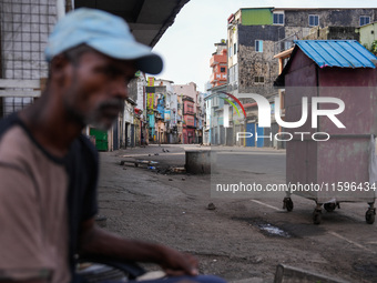 A man sits on the empty street in Colombo, Sri Lanka, on September 22, 2024. A curfew is imposed in Sri Lanka amid the counting of votes in...