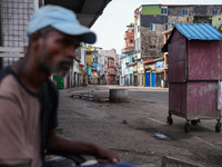 A man sits on the empty street in Colombo, Sri Lanka, on September 22, 2024. A curfew is imposed in Sri Lanka amid the counting of votes in...