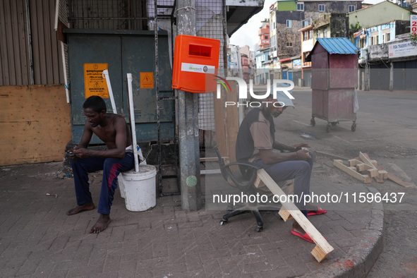 Two people sit on the empty street in Colombo, Sri Lanka, on September 22, 2024. A curfew is imposed in Sri Lanka amid the counting of votes...