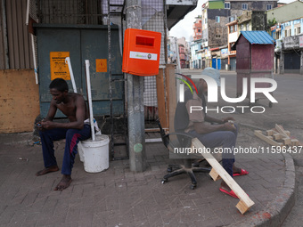 Two people sit on the empty street in Colombo, Sri Lanka, on September 22, 2024. A curfew is imposed in Sri Lanka amid the counting of votes...