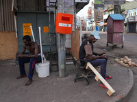 Two people sit on the empty street in Colombo, Sri Lanka, on September 22, 2024. A curfew is imposed in Sri Lanka amid the counting of votes...