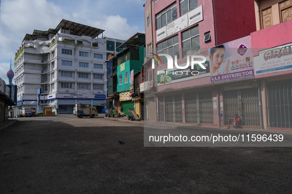 A man sits on the empty street in Colombo, Sri Lanka, on September 22, 2024. A curfew is imposed in Sri Lanka amid the counting of votes in...