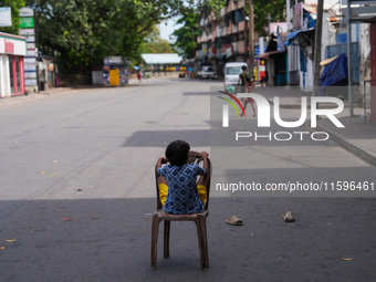 A kid sits on a chair on an empty street in Colombo, Sri Lanka, on September 22, 2024. A curfew is imposed in Sri Lanka amid the counting of...