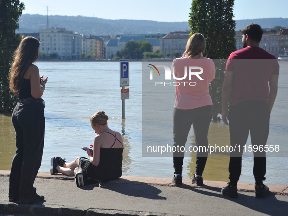 People stand on the bank of the Danube in Budapest, Hungary, as the peak water levels of the Danube are expected to hit today. 