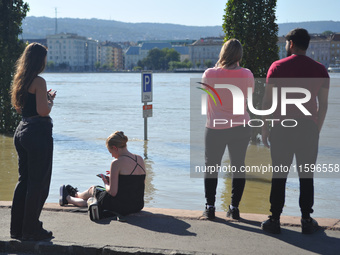 People stand on the bank of the Danube in Budapest, Hungary, as the peak water levels of the Danube are expected to hit today. (