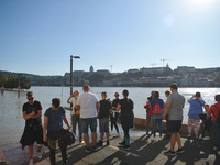 People look at the flooded quay on the bank of the Danube in Budapest, Hungary, as the peak water levels of the Danube are expected to hit t...