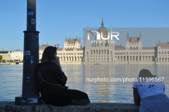 People look at the parliament on the bank of the Danube in Budapest, Hungary, as the peak water levels of the Danube are expected to hit. 