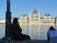 People look at the parliament on the bank of the Danube in Budapest, Hungary, as the peak water levels of the Danube are expected to hit. (