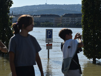 People look at the flooded quay on the bank of the Danube in Budapest, Hungary, on Month Day, Year, as the peak water levels of the Danube a...