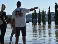 People look at the flooded quay on the bank of the Danube in Budapest, Hungary, on Month Day, Year, as the peak water levels of the Danube a...