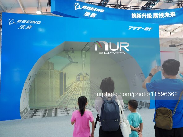 Visitors view a demonstration of the cargo hold automation system of the ''Boeing 777-8F Freighter'' at the 16th International Transportatio...