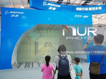 Visitors view a demonstration of the cargo hold automation system of the ''Boeing 777-8F Freighter'' at the 16th International Transportatio...