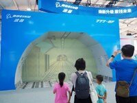 Visitors view a demonstration of the cargo hold automation system of the ''Boeing 777-8F Freighter'' at the 16th International Transportatio...