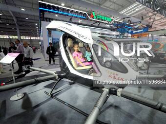 A child experiences an electric unmanned aircraft at the 16th International Transportation Technology and Equipment Exhibition in Beijing, C...