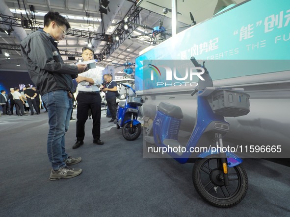 Visitors look at a ''hydrogen two-wheeled vehicle'' at the 16th International Transportation Technology and Equipment Exhibition in Beijing,...