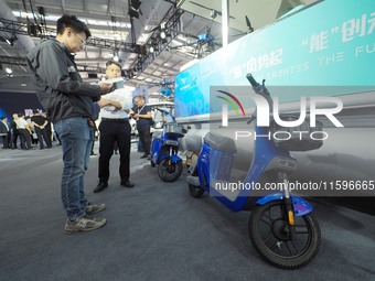 Visitors look at a ''hydrogen two-wheeled vehicle'' at the 16th International Transportation Technology and Equipment Exhibition in Beijing,...