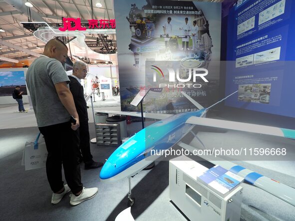 Visitors view a ''hydrogen-powered long-endurance fixed-wing UAV'' at the 16th International Transportation Technology and Equipment Exhibit...