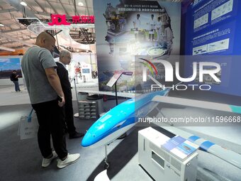 Visitors view a ''hydrogen-powered long-endurance fixed-wing UAV'' at the 16th International Transportation Technology and Equipment Exhibit...