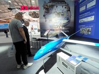 Visitors view a ''hydrogen-powered long-endurance fixed-wing UAV'' at the 16th International Transportation Technology and Equipment Exhibit...