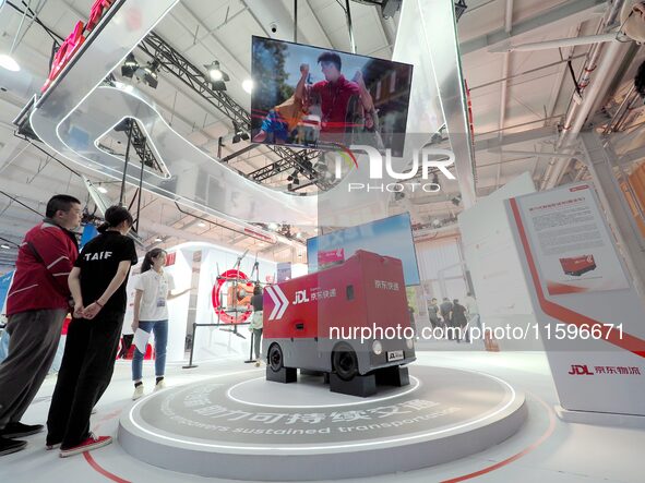 Visitors visit the ''sixth generation intelligent delivery vehicle'' at the booth of JD.com Logistics at the 16th International Transportati...