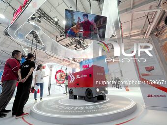 Visitors visit the ''sixth generation intelligent delivery vehicle'' at the booth of JD.com Logistics at the 16th International Transportati...