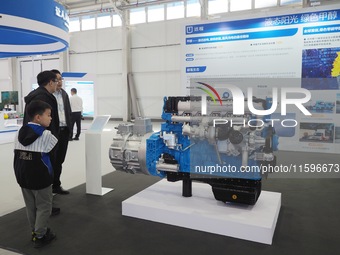 Visitors view a ''methanol engine'' at the 16th International Transportation Technology and Equipment Exhibition in Beijing, China, on Septe...