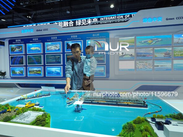 Visitors view a model of the ''Ecological Desilting Project of Taihu Lake'' at the booth of China Communications Construction at the 16th In...