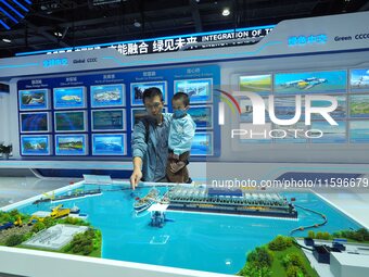 Visitors view a model of the ''Ecological Desilting Project of Taihu Lake'' at the booth of China Communications Construction at the 16th In...