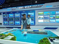 Visitors view a model of the ''Ecological Desilting Project of Taihu Lake'' at the booth of China Communications Construction at the 16th In...