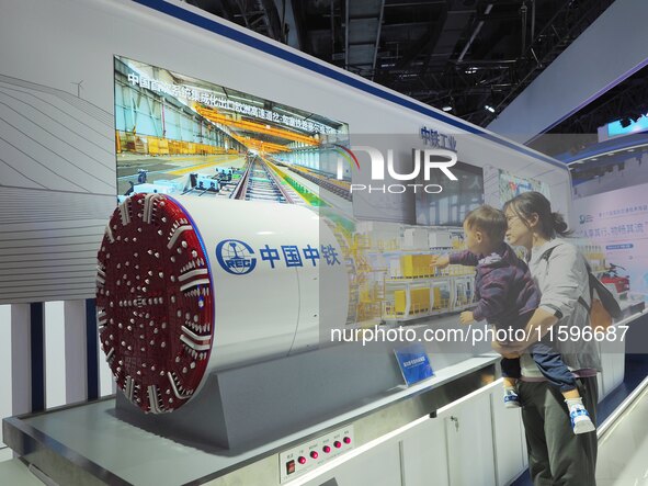 Visitors look at the ''model of the Caucasian Shield Machine'' at the 16th International Transportation Technology and Equipment Exhibition...