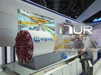 Visitors look at the ''model of the Caucasian Shield Machine'' at the 16th International Transportation Technology and Equipment Exhibition...