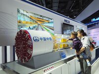 Visitors look at the ''model of the Caucasian Shield Machine'' at the 16th International Transportation Technology and Equipment Exhibition...