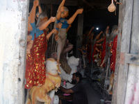 Male and female artists work on a semi-finished idol of the Hindu goddess 'Durga' in Siliguri, India, on September 22, 2024. (