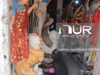 Male and female artists work on a semi-finished idol of the Hindu goddess 'Durga' in Siliguri, India, on September 22, 2024. (