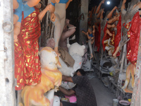 Male and female artists work on a semi-finished idol of the Hindu goddess 'Durga' in Siliguri, India, on September 22, 2024. (