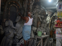 Male and female artists work on a semi-finished idol of the Hindu goddess 'Durga' in Siliguri, India, on September 22, 2024. (