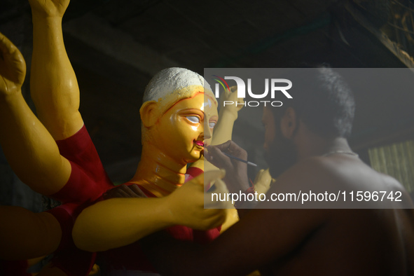 Male and female artists work on a semi-finished idol of the Hindu goddess 'Durga' in Siliguri, India, on September 22, 2024. 