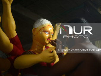 Male and female artists work on a semi-finished idol of the Hindu goddess 'Durga' in Siliguri, India, on September 22, 2024. (