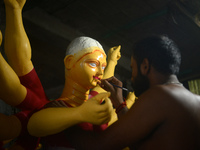 Male and female artists work on a semi-finished idol of the Hindu goddess 'Durga' in Siliguri, India, on September 22, 2024. (