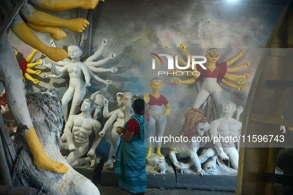 Male and female artists work on a semi-finished idol of the Hindu goddess 'Durga' in Siliguri, India, on September 22, 2024. 