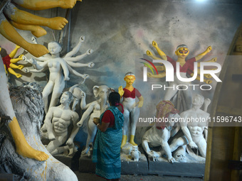 Male and female artists work on a semi-finished idol of the Hindu goddess 'Durga' in Siliguri, India, on September 22, 2024. (